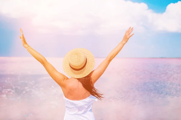 夏日阳光灿烂，戴着帽子的女人在粉色盐湖畔散步. — 图库照片