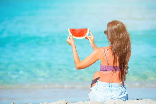 Chica feliz divirtiéndose en la playa y comiendo sandía — Foto de Stock