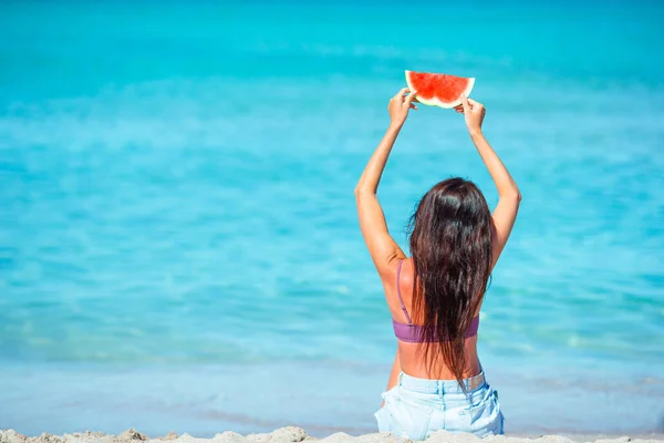 Mutlu kız sahilde eğleniyor ve karpuz yiyor. — Stok fotoğraf