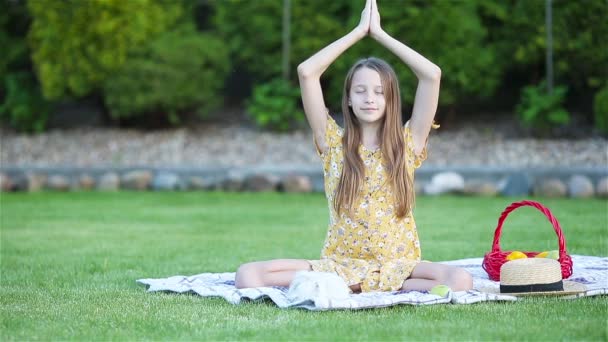 Kleines Mädchen in Yogaposition im Park. — Stockvideo