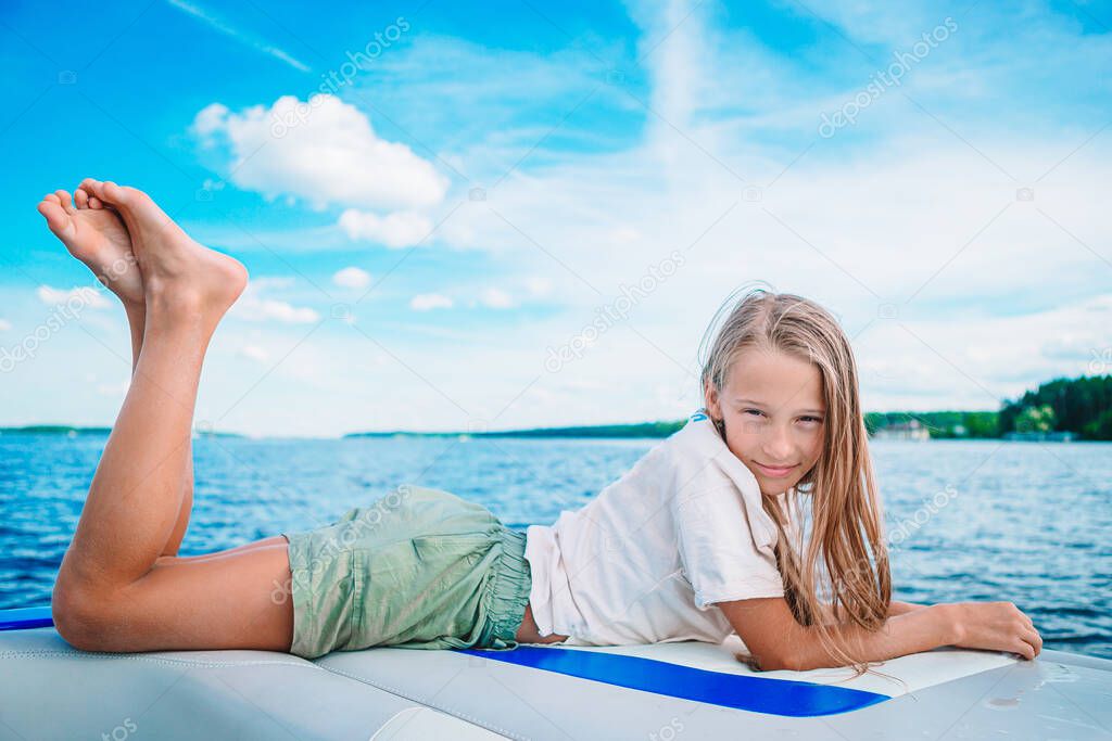 Little girl sailing on boat in clear open sea