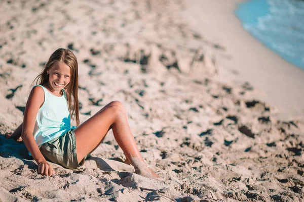 Kleines Mädchen am tropischen weißen Strand bei Sonnenuntergang — Stockfoto
