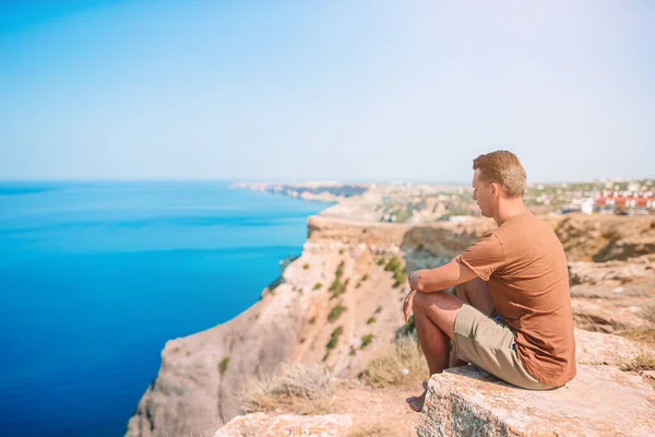 Tourist man outdoor on edge of cliff seashore — Stock Photo, Image