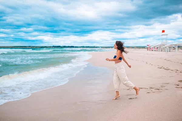 Mladá žena v bílém na pláži — Stock fotografie