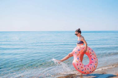 Plaj tatilindeki şapkalı genç kadın.