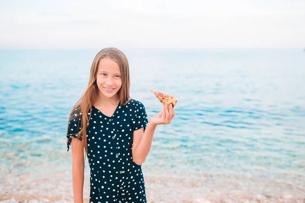 Ragazza felice che fa un picnic con la pizza sulla spiaggia — Foto Stock