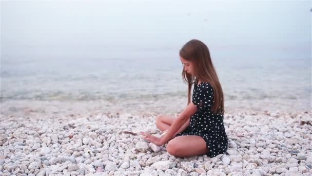 Schattig klein meisje aan het strand tijdens de zomervakantie — Stockvideo