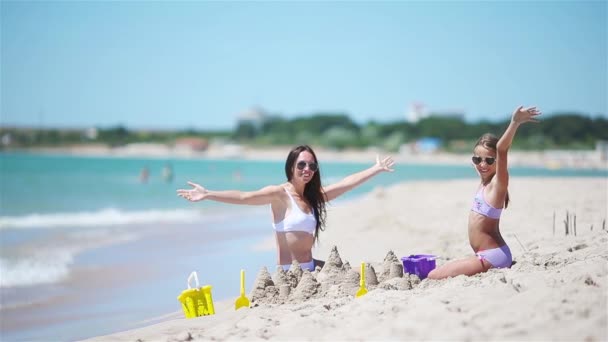 Gyönyörű anya és lánya a strandon élvezi a nyári vakációt — Stock videók