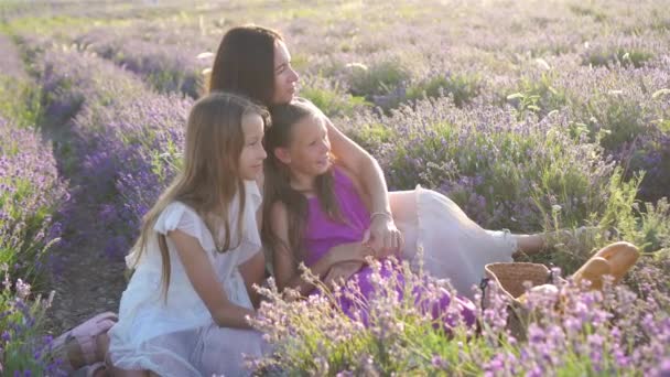 Familia en el campo de flores de lavanda al atardecer en vestido blanco y sombrero — Vídeos de Stock