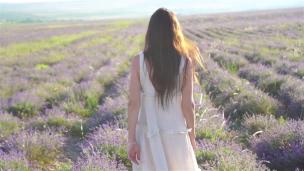 Donna in campo fiori di lavanda al tramonto in abito bianco e cappello — Video Stock