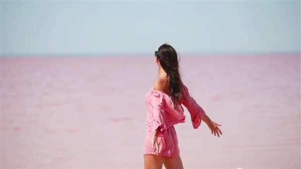 Kobieta w kapeluszu spacer na różowym słonym jeziorze w słoneczny letni dzień. — Wideo stockowe