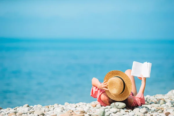 Молодая женщина читает книгу во время тропического белого пляжа — стоковое фото