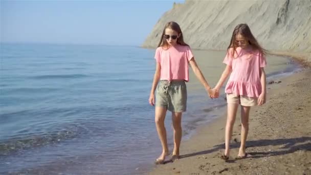 Маленькие веселые девочки веселятся на тропическом пляже, играя вместе.. — стоковое видео