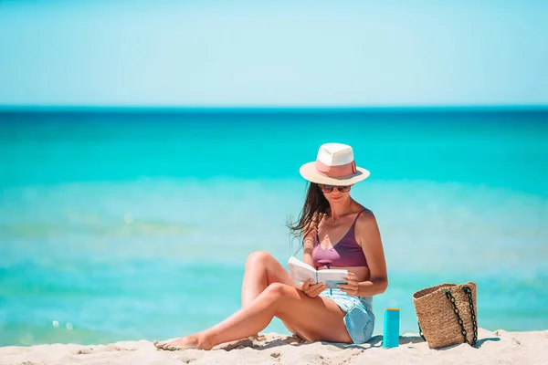 Giovane donna che legge libro durante la spiaggia tropicale bianca — Foto Stock