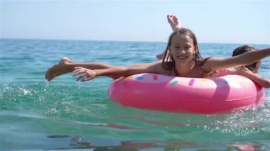 Küçük kızlar yaz tatilinde tropik plajda eğleniyorlar. Birlikte oynuyorlar.