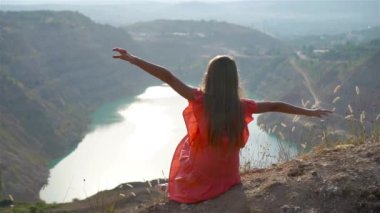 O zamanlar gölün yanında arka planda inanılmaz bir doğası olan küçük bir kız.