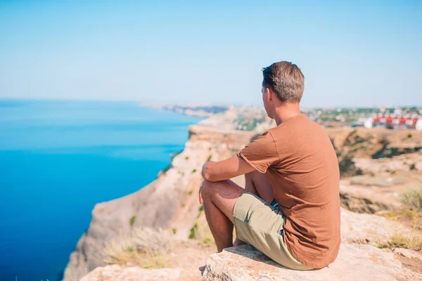 Tourist man outdoor on edge of cliff seashore — Stock Photo, Image