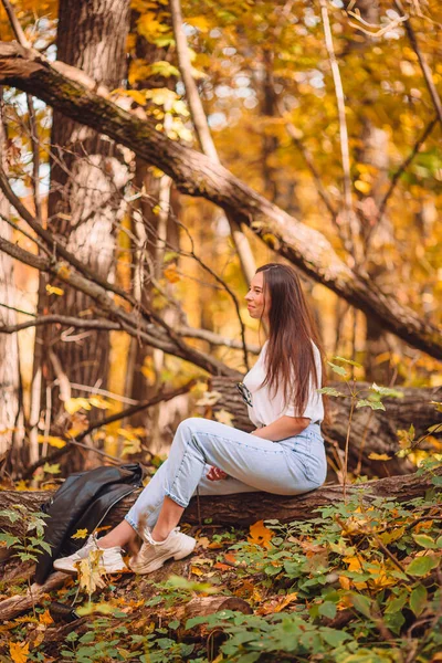 Осенняя концепция - красивая женщина в осеннем парке под осенней листвой — стоковое фото