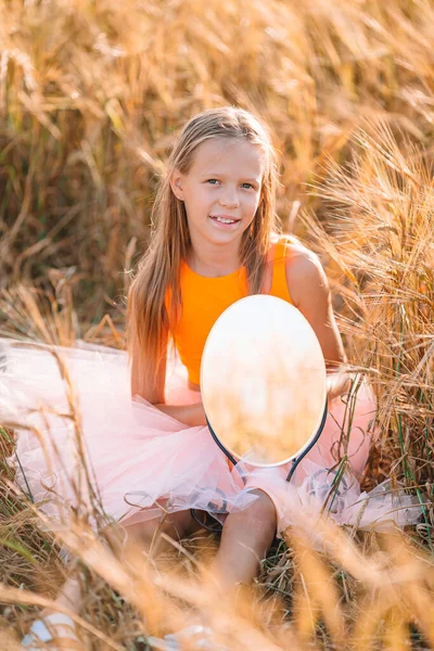 Bedårande förskoleflicka går lyckligt i vetefält på varm och solig sommardag — Stockfoto