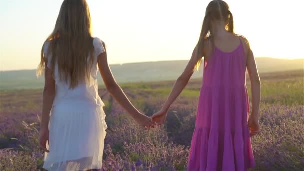 Dívky v levandulových květinách pole při západu slunce v bílých šatech