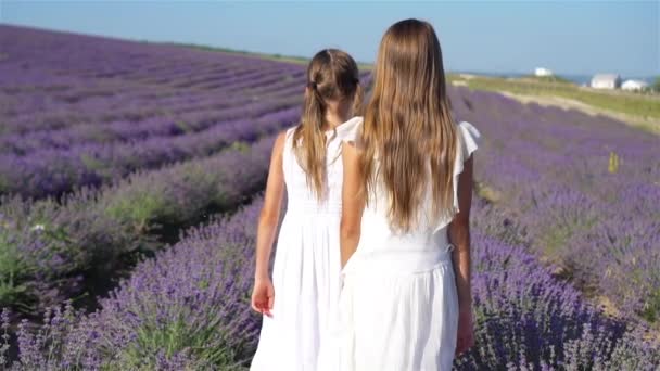 Meisjes in lavendel bloemen veld bij zonsondergang in witte jurk — Stockvideo