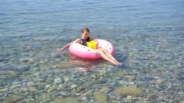 Schattig meisje op opblaasbare lucht matras in de zee — Stockvideo