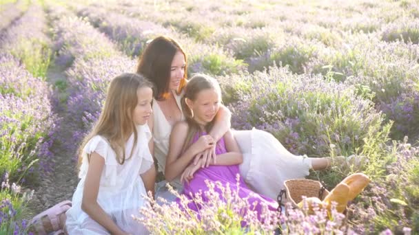 Сім'я в лавандовому полі квітів на заході сонця в білій сукні і капелюсі — стокове відео