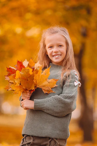 Portrait of adorable little girl with yellow leaves bouquet in fall — Stock Photo, Image