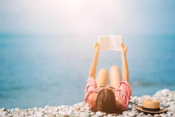 Fiatal nő olvasás könyv alatt trópusi fehér strand — Stock Fotó