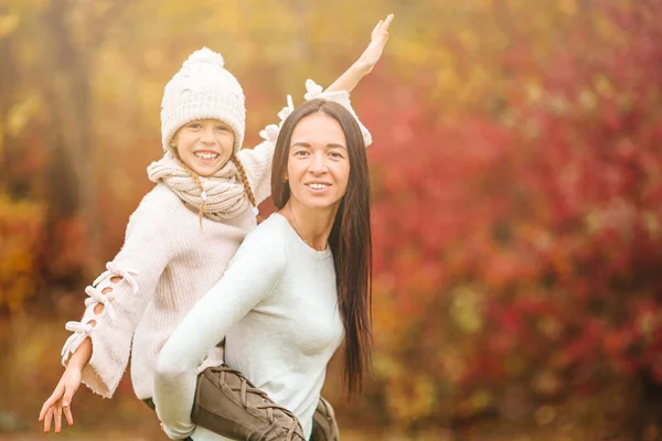 Little girl with mom outdoors in park at autumn day — Stock Photo, Image