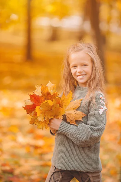Portret van schattig klein meisje met gele bladeren boeket in de herfst — Stockfoto