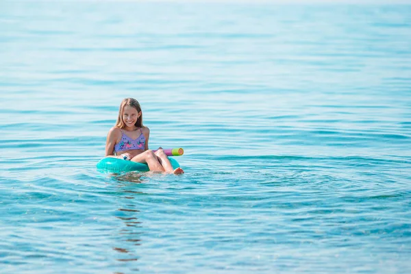 愛らしい女の子オンインフレータブル空気マットレスで海 — ストック写真