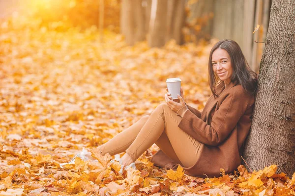 秋天的概念-美丽的女人在秋天的树叶下喝咖啡 — 图库照片