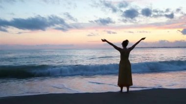 Okyanusun arka planında gün batımında güzel bir kadın