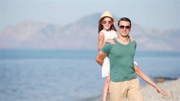Mała dziewczynka i szczęśliwy tata zabawy podczas wakacji na plaży — Wideo stockowe