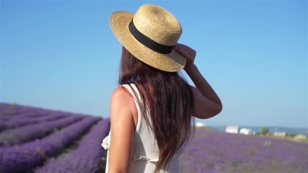 Žena v levandulové květy pole při západu slunce v bílých šatech a klobouku — Stock video