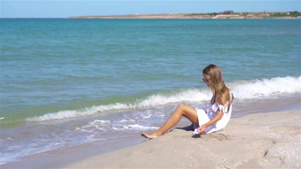 Schattig klein meisje aan het strand tijdens de zomervakantie — Stockvideo