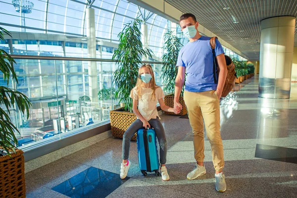 Táta a malá holka s nedickými maskami na letišti. Ochrana proti koronaviru a sevření — Stock fotografie