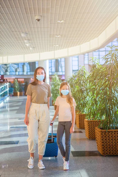Havaalanında maskeli bir anne ve küçük kız. Coronavirus ve Gripp 'e karşı koruma — Stok fotoğraf