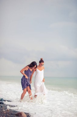 Plajda beyazlar içindeki genç kadınlar