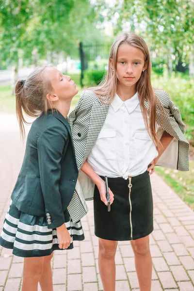 Duas garotinhas fofas posando na frente de sua escola. — Fotografia de Stock