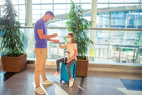 Dad and little girl with medical masks at airport. Protection against Coronavirus and gripp — Stock Photo, Image