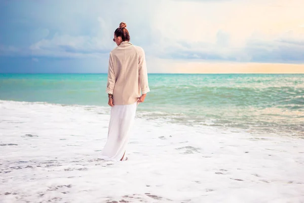 Žena leží na pláži a užívá si letní prázdniny při pohledu na moře — Stock fotografie