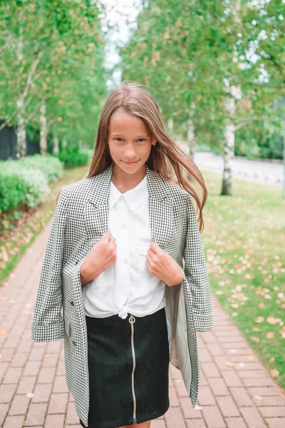 Bonito smilling menina posando na frente de sua escola — Fotografia de Stock