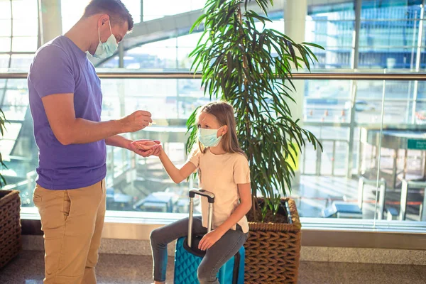Táta a malá holka s lékařskými maskami na letišti. Ochrana proti koronaviru a sevření — Stock fotografie