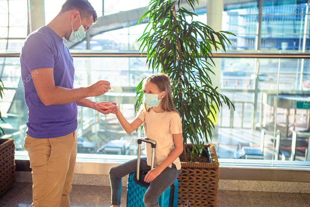 Dad and little girl with medical masks at airport. Protection against Coronavirus and gripp