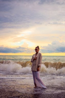 Kumsaldaki kadın yaz tatilinin tadını çıkarıyor.