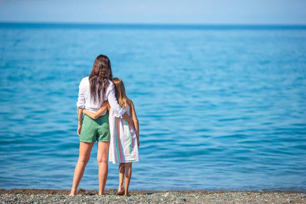 愛らしい女の子と若いです母上の熱帯の白いビーチ — ストック写真