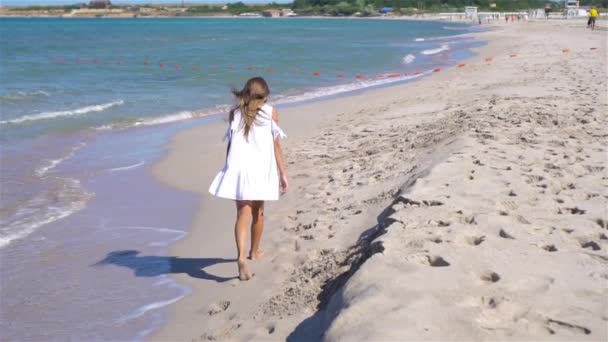 Χαριτωμένο κοριτσάκι στην παραλία κατά τη διάρκεια των καλοκαιρινών διακοπών — Αρχείο Βίντεο