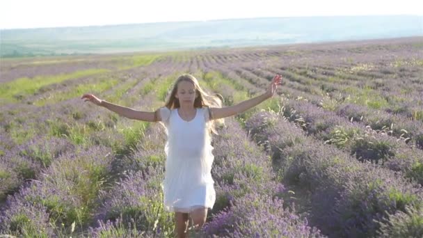 Femme au champ de fleurs de lavande au coucher du soleil en robe blanche et chapeau — Video